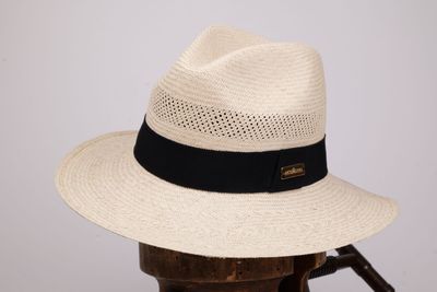 Le chapeau est blanc et noir, avec un ruban noir.