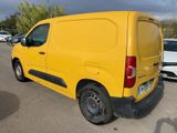 yellow van parked in a parking lot with other cars in the background