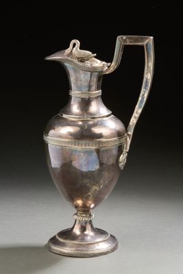 an antique silver plated pitcher with a handle on a stand
