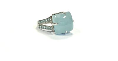 a close up of a ring on a white surface with diamonds