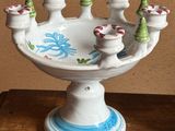 a white candle holder that has a bunch of candles on it