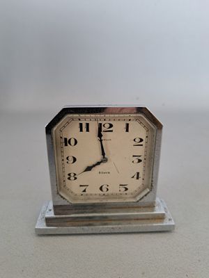 une petite horloge posée sur une table