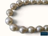 pearl necklace on a white background with a blue tag on it