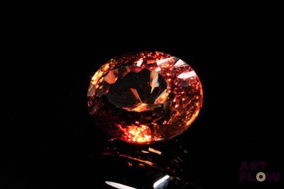 a close up of a diamond on a black surface with a pair of scissors