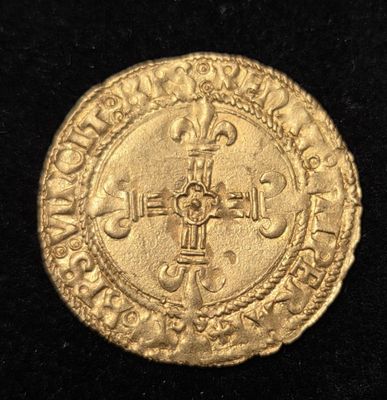 Gros plan sur une pièce d'or ornée d'une croix