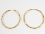 a pair of gold hoop earrings on a white background