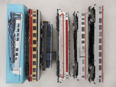 Plusieurs trains miniatures sont alignés les uns à côté des autres sur une table