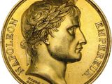 a close up of a gold coin with a man ' s face