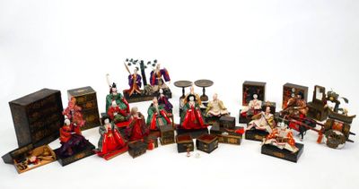 de nombreuses figurines représentant des personnes assises sur une surface blanche
