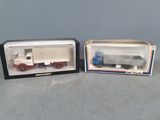 two boxed toy trucks are sitting side by side on a table
