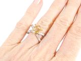 a woman ' s hand holding a ring with a yellow diamond