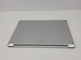 the back of a silver laptop computer sitting on top of a white table