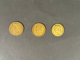 trois pièces d'or posées les unes à côté des autres sur une table