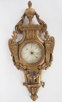 une horloge en or accrochée au mur, sur laquelle sont représentés deux oiseaux
