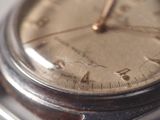 a close up of a silver watch with a brown face