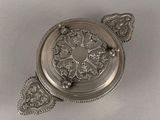 an antique silver plate with a decorative design on it