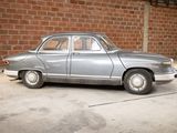 a silver car that is parked in front of a brick wall