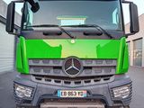 un camion vert garé sur un parking
