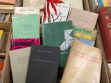 de nombreux livres qui se trouvent dans une boîte posée par terre