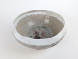 a white bowl with a bear in it on a table