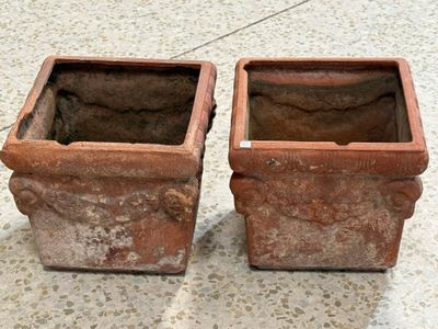 deux pots marron posés par terre l'un à côté de l'autre