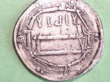 a silver coin with a picture on it on a green surface