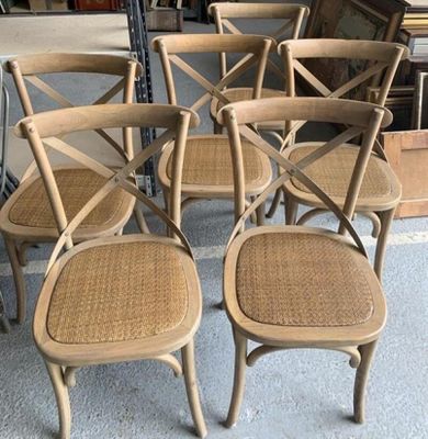 quatre chaises en bois avec des assises en osier dans un magasin