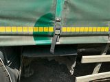 a green truck with a yellow stripe on the side of it