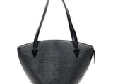 un sac à main noir muni d'une poignée noire sur fond blanc