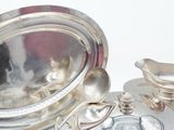 a silver plate with a silver spoon and a silver plate with a silver spoon