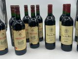 six bottles of red wine are lined up on a table