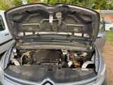 une voiture dont le capot est ouvert et dont le moteur se trouve dans le coffre