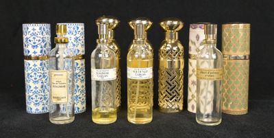 plusieurs flacons de parfum posés les uns à côté des autres sur une surface noire