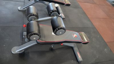 a gym bench that has a pair of weights on top of it