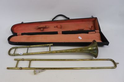trois trombones en laiton dans un étui muni d'une poignée noire