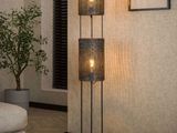 a close up of a lamp on a wooden floor next to a couch