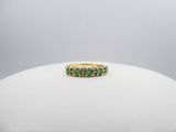 a close up of a gold ring with emerald stones