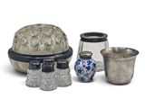 three glass vases and a silver container on a white surface