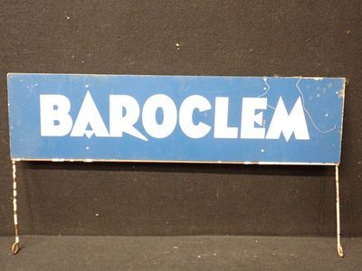 enseigne « Barocleaa » bleue et blanche sur un socle, sur fond noir