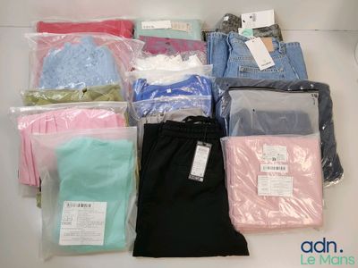 de nombreux types de vêtements différents, rangés dans des sacs posés sur la table