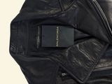 black leather jacket with zippers and a tag attached to it