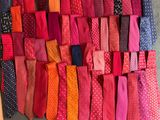 de nombreuses cravates de différentes couleurs disposées sur un mur