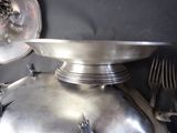 a large metal bowl with forks and spoons on top of it