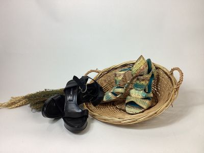 un panier contenant une paire de chaussures noires et une paire de chaussures noires