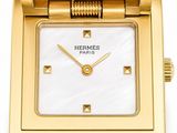 an image of a gold watch with a white face and brown leather strap