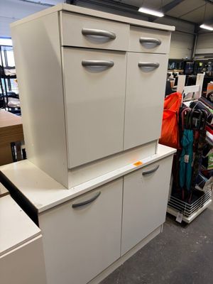 une armoire blanche à tiroirs dans un magasin où se trouvent d'autres articles