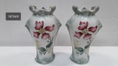 two vases with flowers painted on them sitting on a table