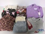 a pile of sweaters that are sitting on a table