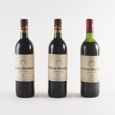 trois bouteilles de vin sont alignées sur une surface blanche