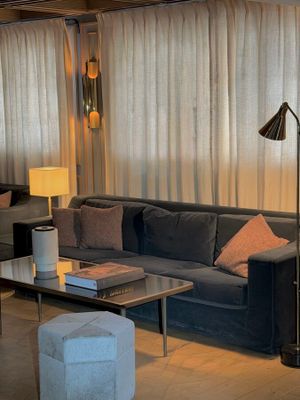 a living room with a couch, chair, table and lamp